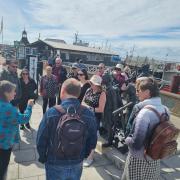Trail- A group of walkers stood by Harwich's holocaust memorial on the history walk.