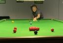 Eagle-eyed – a snooker playeraims for a pack of reds