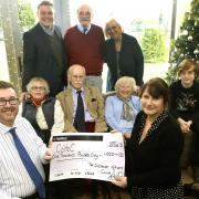 Manager of the Officers' Club John Scarff and members present a cheque for £1,000