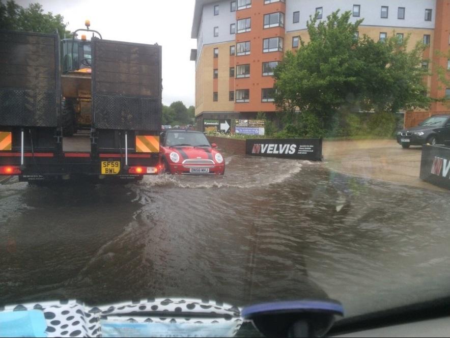 A mini struggling through floodwater in Haven Road, one of the worst-hit areas. Picture by Simon Davis