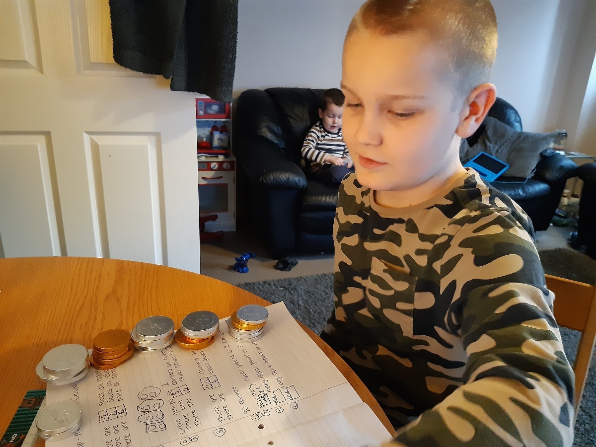Sweet treat - year four pupil Charlie Reed, working out his maths problems using chocolate coins