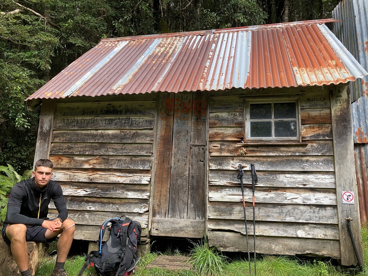 Resting point - Shay alongside Martin’s Hut, a classic New Zealand hut