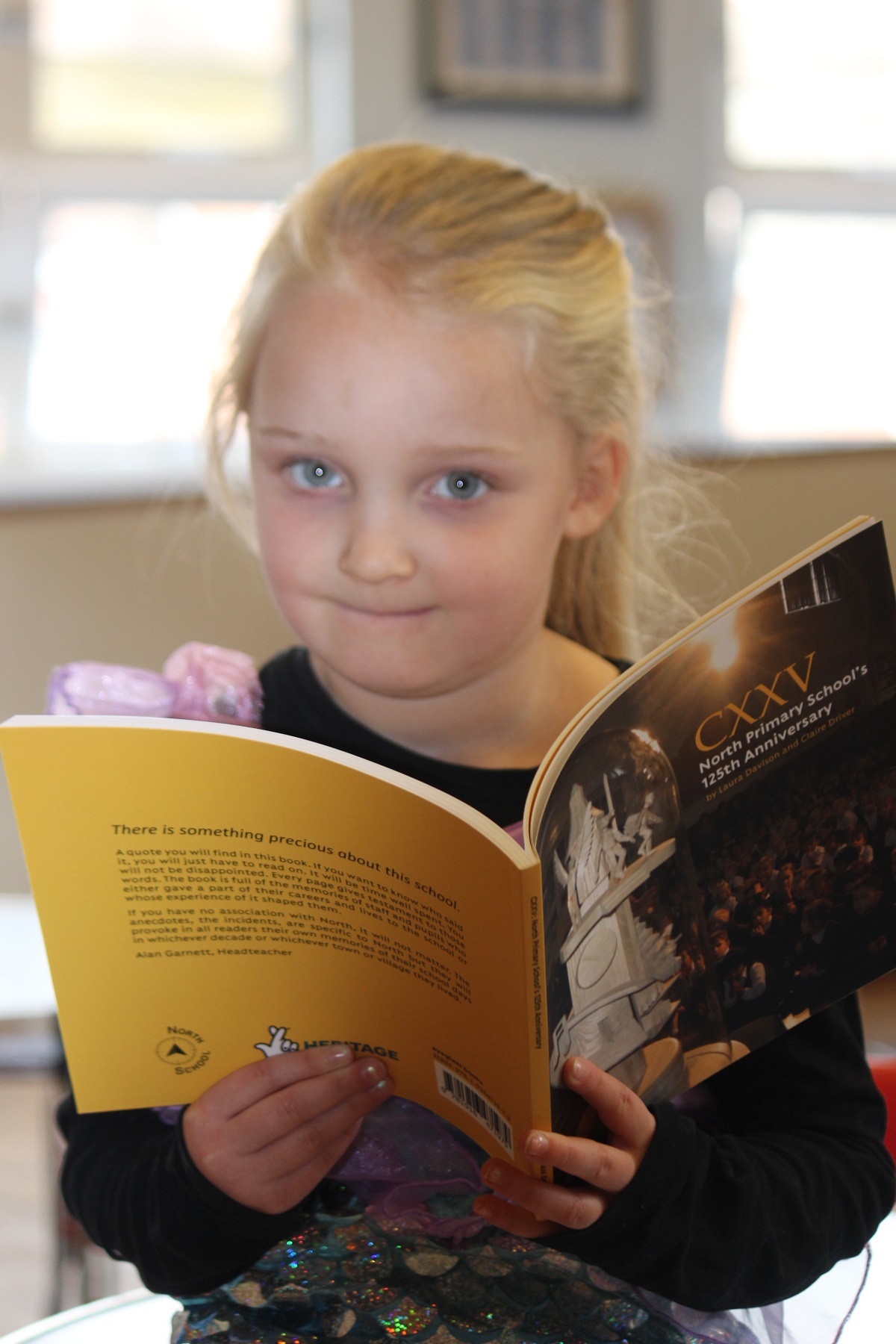 Important role - at a school birthday party in November 2019, Poppy Lynn was the youngest pupil in the school. She helped cut the cake with the oldest pupil. Their photo is in the book