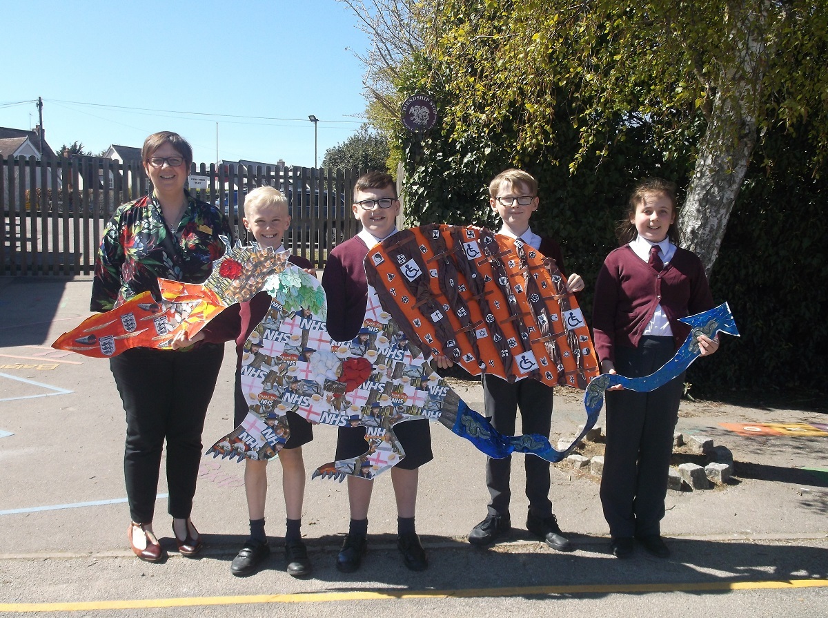 Playing with fire - headteacher Rebecca Keitch and Class 4 pupils Daniel Harden, Harry Batts, Bobby Branchflower and Amelie Singleton with their very own dragon