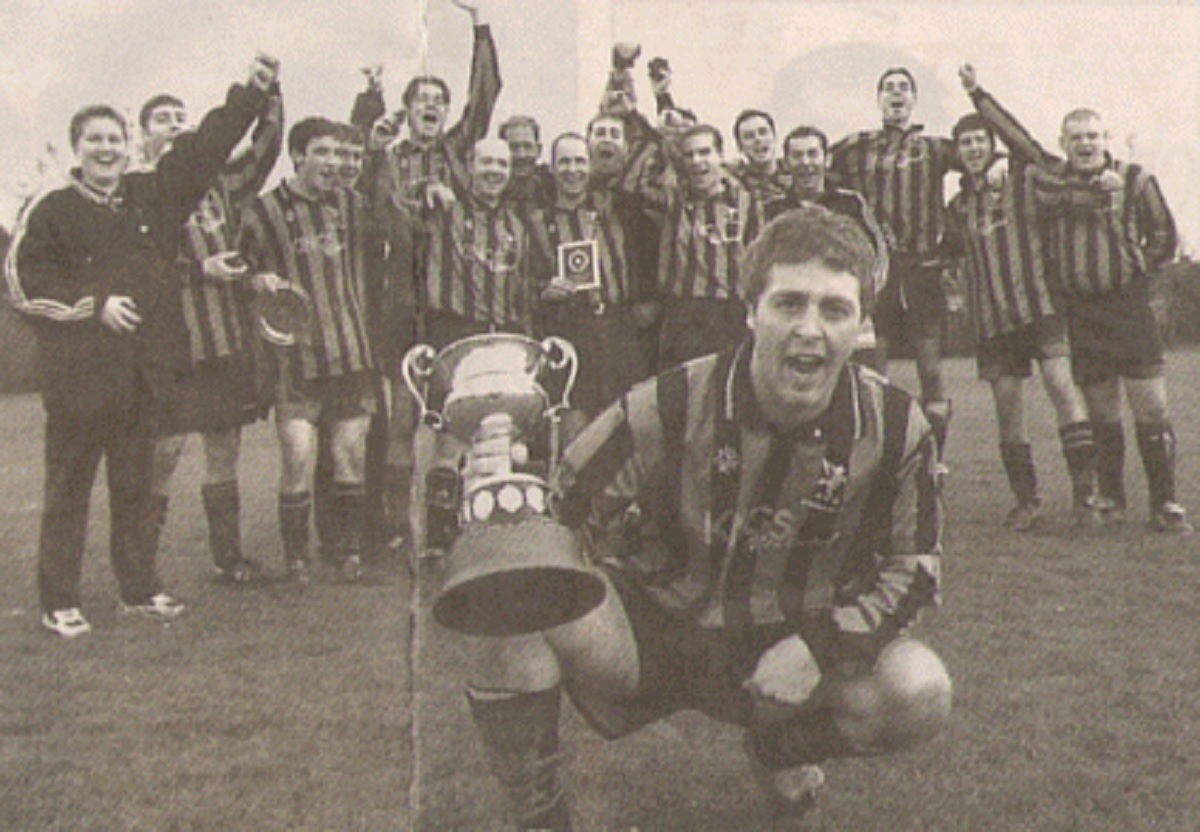 Emphatic - Andy Orrin holds the Ernie Osborne Challenge Cup aloft, watched by his AFC Pegasus Reserves team-mates, after they thumped Foundry Arms 9-0 in the 1999/2000 campaign