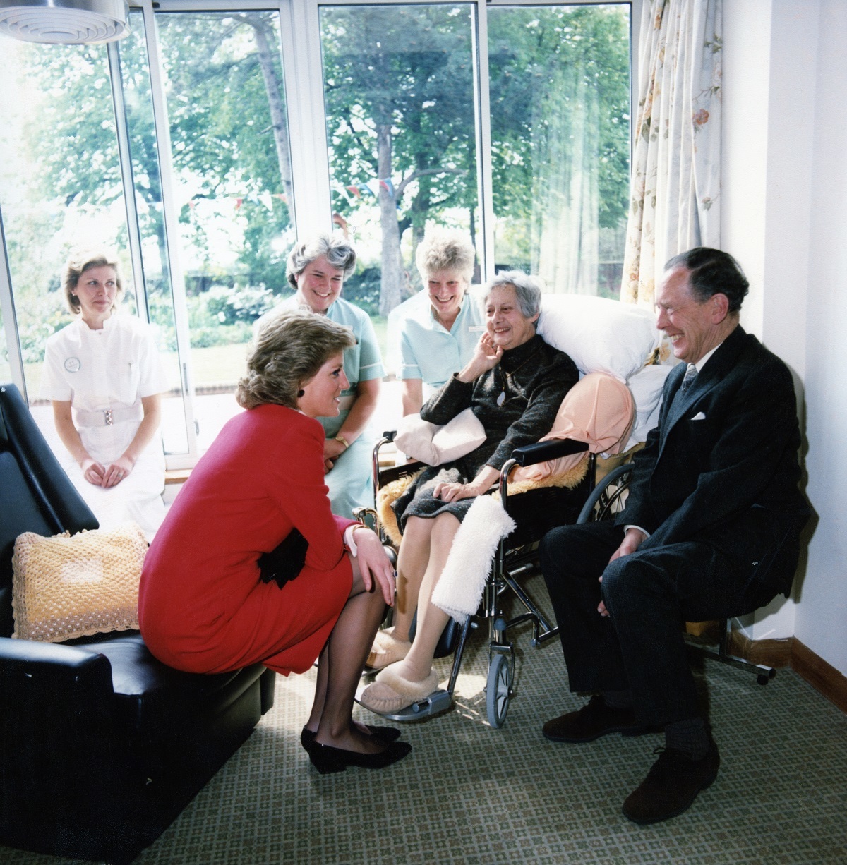 Smiles all round - the royal visitor sits down for a chat with a patient and family