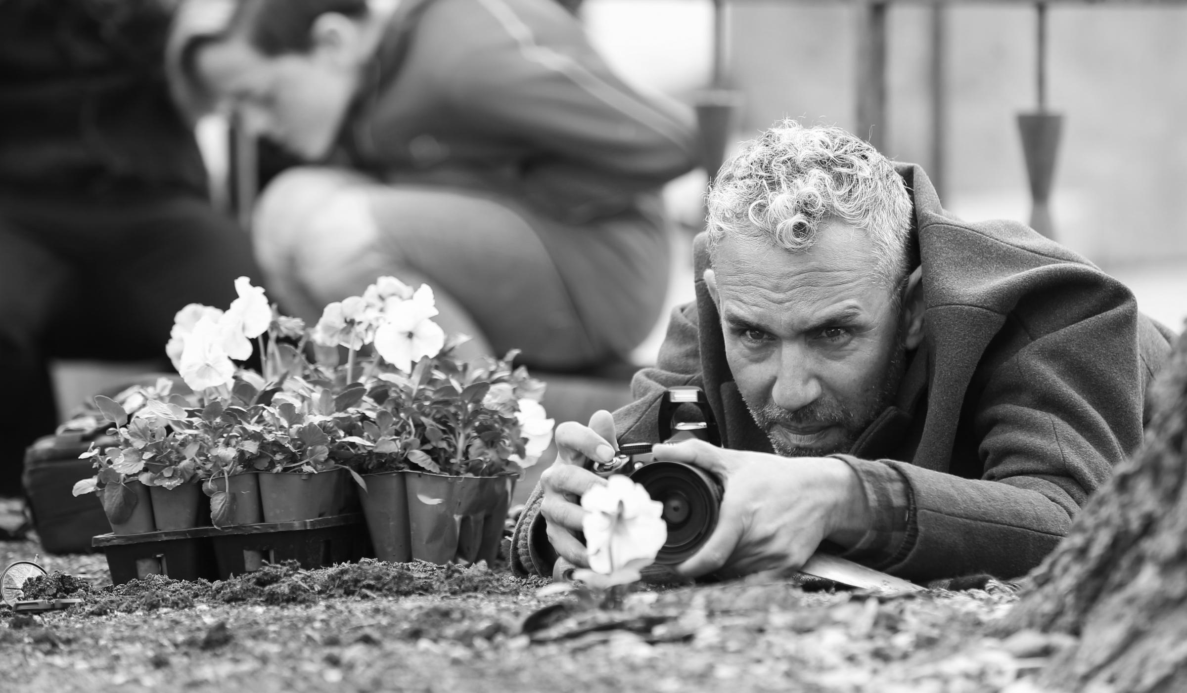 Artist - Paul Harfleet snaps a pansy at the University of Kansas and (inset) one of the flowers in Colchester Picture: Nick Krug