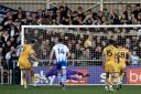 Full stretch - Colchester United goalkeeper Owen Goodman dives to his right to make a crucial save from Sutton United's Harry Smith