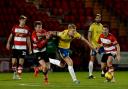 Heads up - Colchester United defender Zach Mitchell finds himself surrounded at Doncaster Rovers