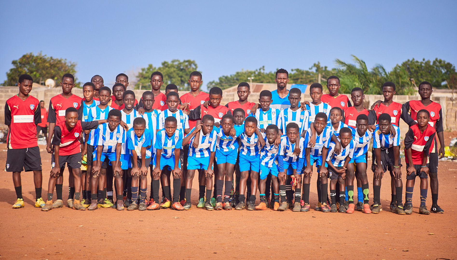 Fierté - Enfants ghanéens avec des bottes et un kit donnés par le président de Colchester Uniteds, Robbie Cowling et expédiés par Boots2Africa