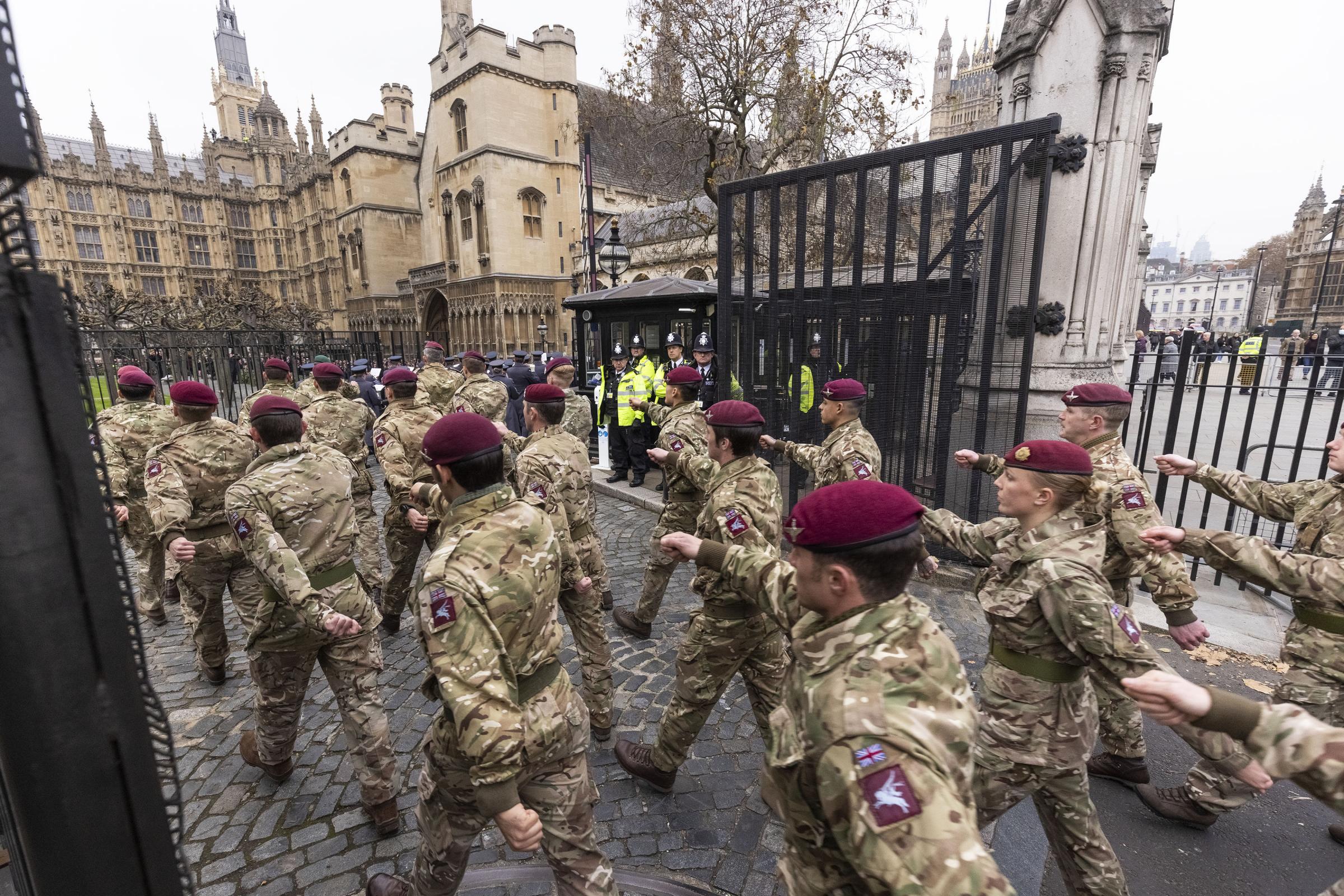 On parade - members of 16 Air Assault Brigade Combat Team marching into Parliament in London. Inset: The troops being greeted by Prime Minister Boris Johnson