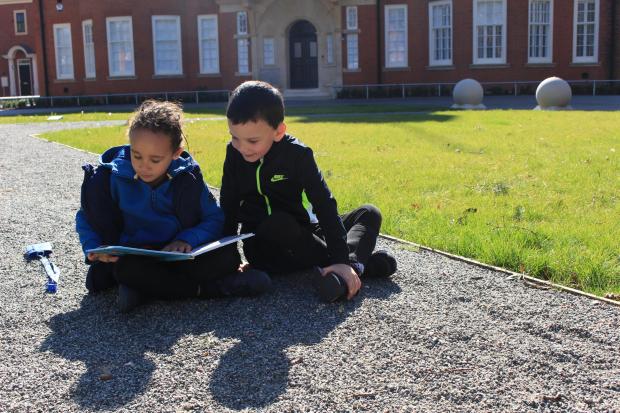 Gazette: Reading in the sunshine – two youngsters read a book together in the spring sun