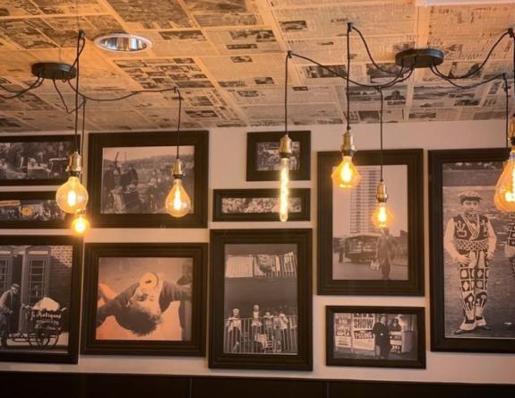 Gazette: Inside - a selection of photographs on the walls alongside a newspaper-designed ceiling Gazette: Inside - a selection of photographs on the walls alongside a newspaper-designed ceiling