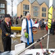Blessed - Rev Canon Laurie Bond, area dean of St Osyth blessing a boat at The Hard with water, bowl held by Roger Tabor the Lord Warden of the Cinque Ports’ Droitgatherer. Credit: Jon Sturdy