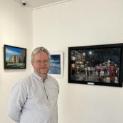 Proud - Peter standing in front of his work, which is currently on show.