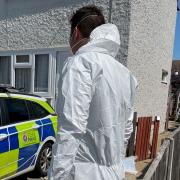Murder probe - an officer at the Baxters' property in Victory Road