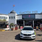 Emergency - a police car parked in front of Clacton Pier as officers search for a missing swimmer