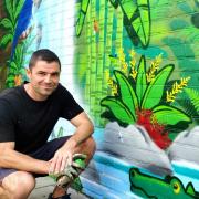 Artist - Adrian Leroy in front of his mural at the Mayflower Forest School in Harwich